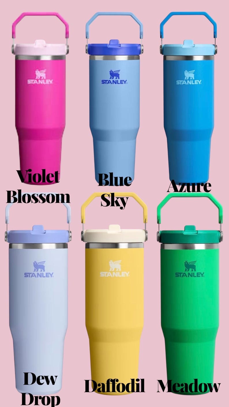 May include: A collection of Stanley tumblers in various colors, including violet, blue, azure, dew drop, daffodil, and meadow green. Each tumbler has a handle and the Stanley logo. The text "Violet Blossom", "Blue Sky", "Azure", "Dew Drop", "Daffodil", and "Meadow" are displayed.
