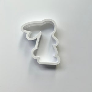 May include: White plastic cookie cutter shaped like a bunny rabbit.