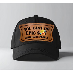 Puede incluir: Gorra de béisbol negra con visera curva. La gorra presenta un parche rectangular marrón con el texto "YOU CAN'T DO EPIC S**T WITH BASIC PEOPLE" y un emoji riendo.