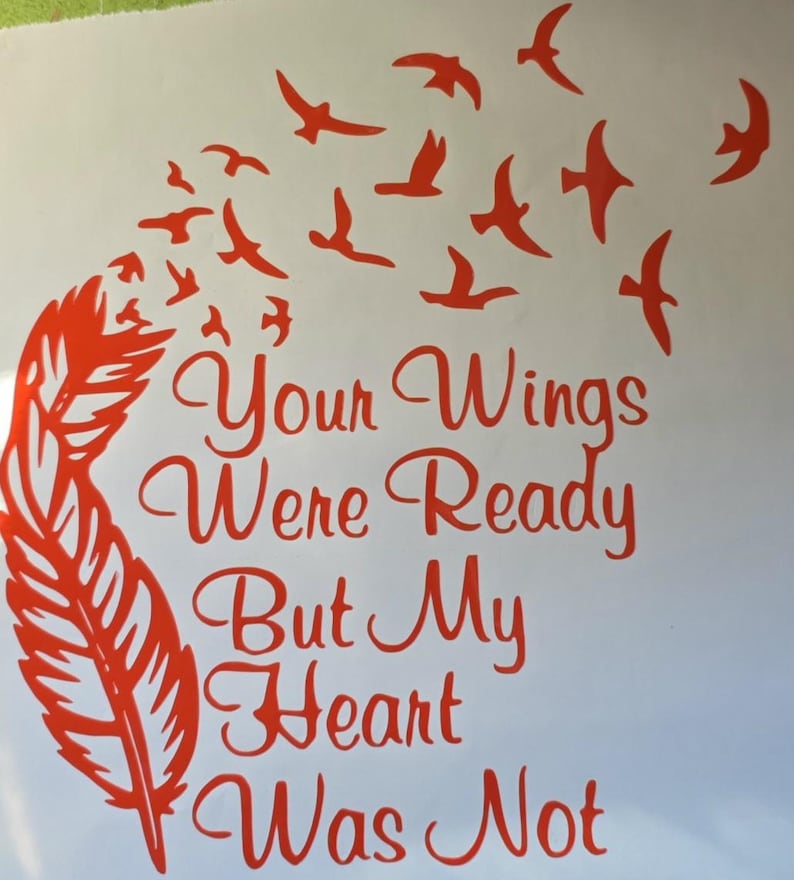 Op de afbeelding: Een rode vinyl sticker met een grote veer aan de linkerkant die overgaat in een zwerm kleine vogels die omhoog vliegen. De tekst "Your Wings Were Ready But My Heart Was Not" staat in een cursief lettertype in het midden.