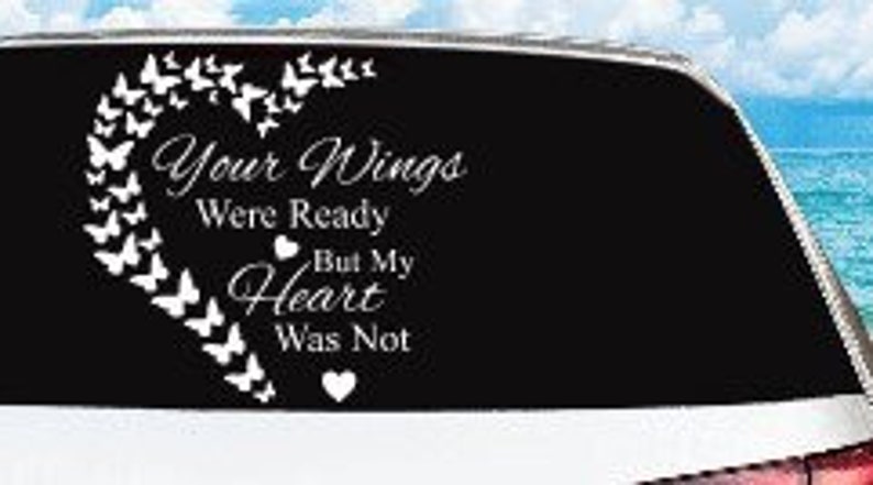 May include: A white vinyl decal applied to a car window. The decal features a heart-shaped design made of butterflies, with the text "Your Wings Were Ready But My Heart Was Not."