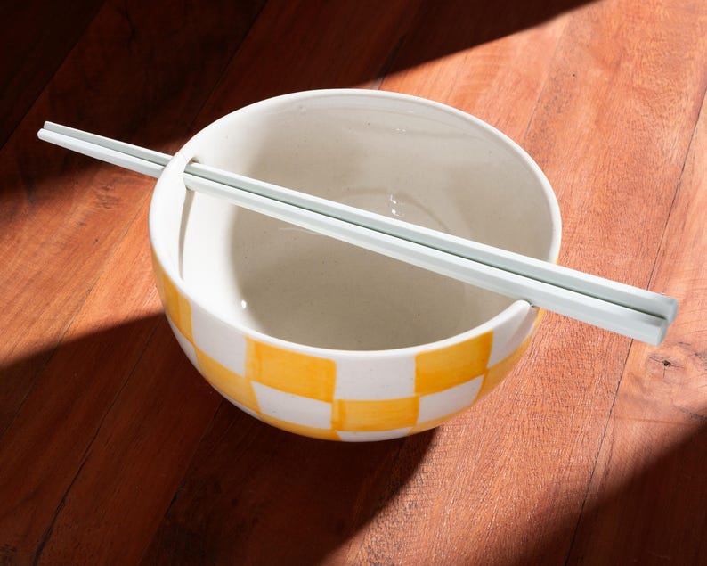 Handcrafted ceramic ramen noodle bowl with built-in chopstick holder and hand-painted yellow checkered design