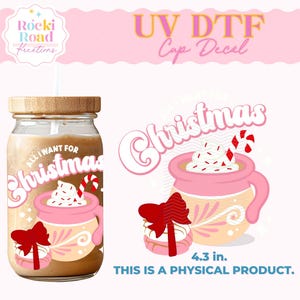 May include: A pink and white Christmas themed mug with a red bow and candy cane. The mug is filled with a brown liquid and topped with whipped cream and red sprinkles. The text "All I Want For Christmas" is printed on the mug. The mug is 4.3 inches in diameter. This is a UV DTF cup decal.