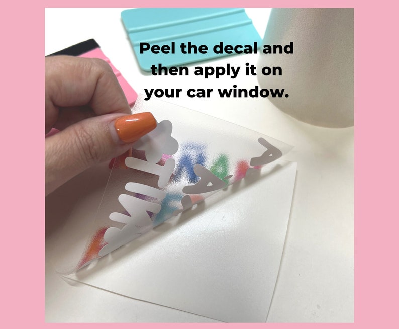 May include: A hand peeling back a clear transfer sheet to reveal a colorful vinyl decal that says "FAMILY". The decal is on a white background. The text "Peel the decal and then apply it on your car window." is visible in the image.