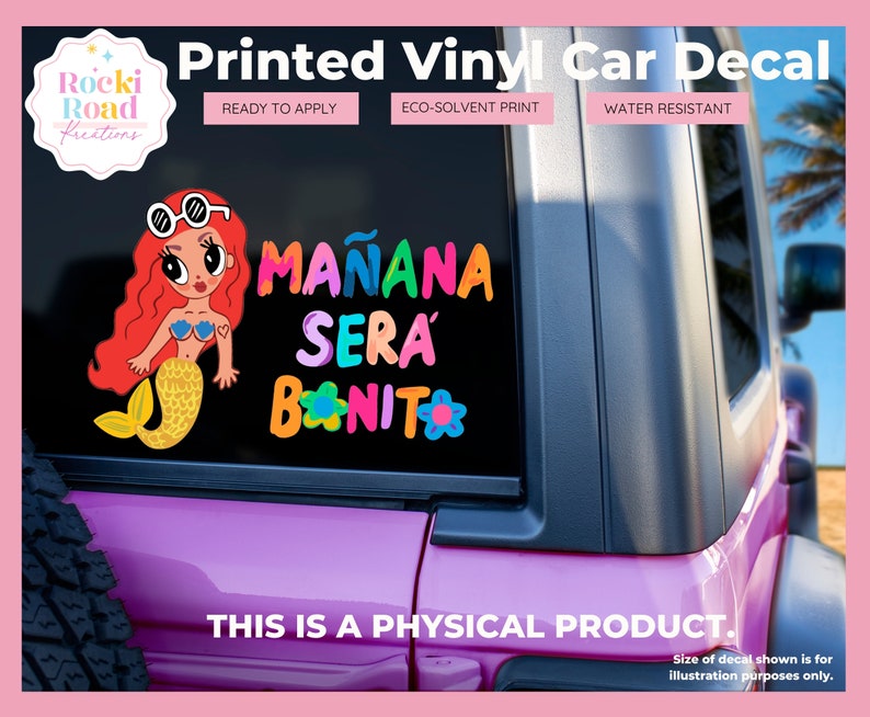 May include: A pink car with a vinyl decal on the back window. The decal features a mermaid with red hair and a yellow tail, and the text "MA&Ntilde;ANA SERA BONITO" in colorful letters.