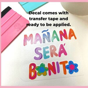 May include: A colorful vinyl decal with the text "MA&Ntilde;ANA SER&Aacute; BONITO" in a rainbow of colors with a flower design. The decal comes with transfer tape and is ready to be applied.