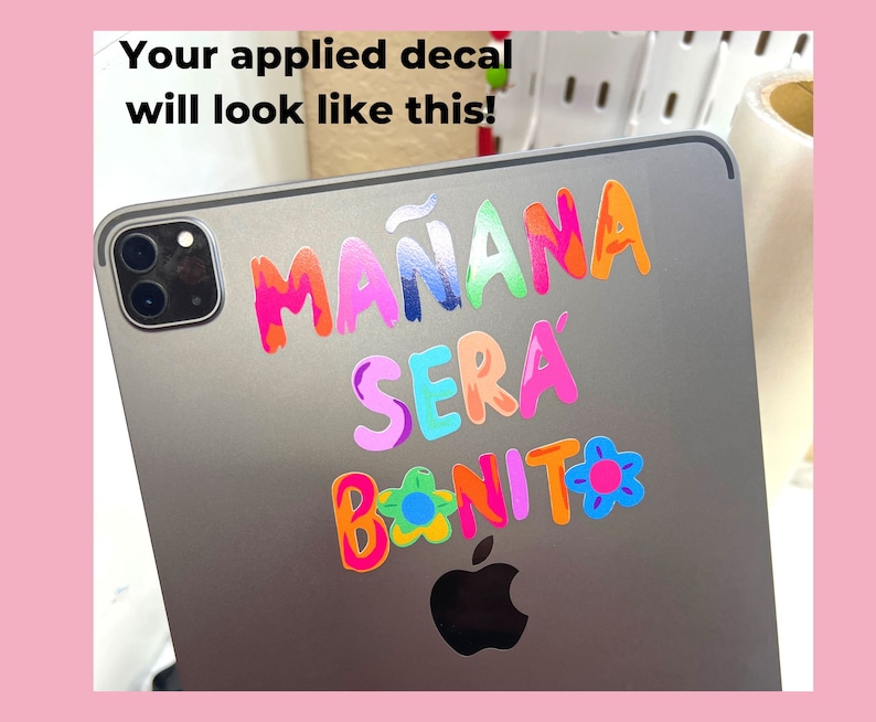 May include: A silver iPad with a colorful decal that reads "Ma&ntilde;ana ser&aacute; bonito" with a flower design.