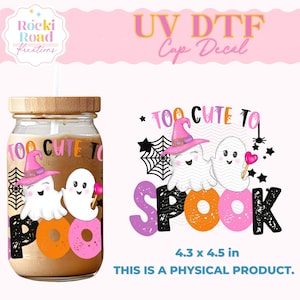 May include: A Halloween-themed cup decal featuring two cartoon ghosts wearing witch hats, the text "TOO CUTE TO SPOOK", and a spider web design. The decal is 4.3 x 4.5 inches and is a physical product.