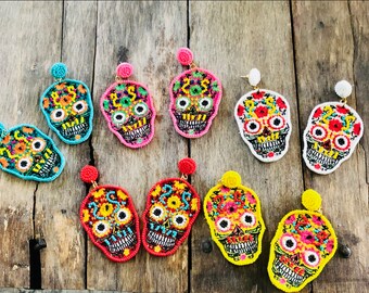May include: A set of 10 colorful beaded skull earrings. The earrings are made with colorful beads and feature a skull design with floral details. The earrings are perfect for adding a touch of whimsy to any outfit.