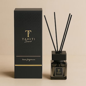 Può includere: Un diffusore di fragranze per la casa nero con una scatola abbinata. La scatola e il diffusore sono adornati con scritte dorate che recitano "TAHITI Scent" e "home fragrance". I bastoncini neri sono inseriti nella bottiglia del diffusore.
