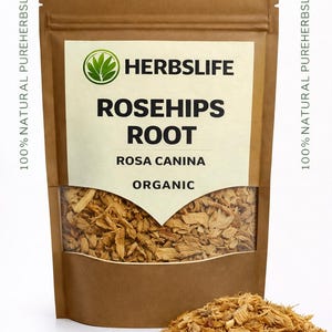 Könnte beinhalten: Ein brauner Papiersack mit einem transparenten Fenster, das Hagebuttenwurzel zeigt. Der Beutel hat ein weißes Etikett mit dem Text "HERBSLIFE ROSEHIPS ROOT ROSA CANINA ORGANIC". Ein kleiner Haufen Hagebuttenwurzel liegt vor dem Beutel.