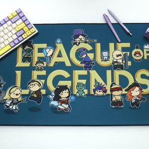 May include: A blue and gold League of Legends themed mouse mat with a variety of characters from the game. The text "League of Legends" is in gold lettering.