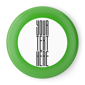 May include: Green frisbee with a white center and the text "YOUR TEXT HERE" printed in black.