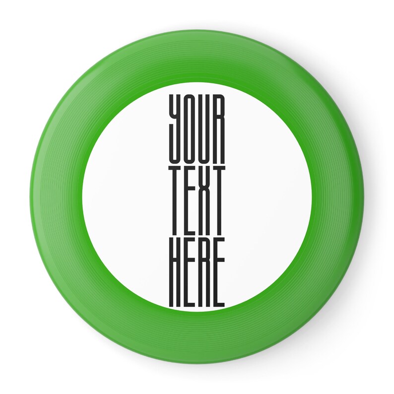 May include: Green frisbee with a white center and the text "YOUR TEXT HERE" printed in black.