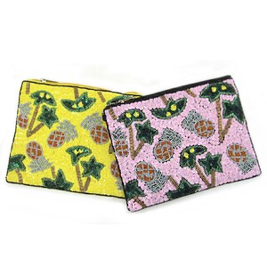 May include: Two beaded clutches with a pineapple and palm tree design. One clutch is yellow and the other is pink.