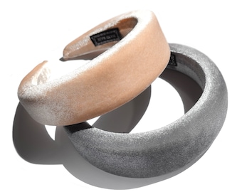 May include: Two velvet headbands, one in a light beige color and the other in a dark gray color. The headbands are thick and wide, and they are both made of a soft, plush velvet.