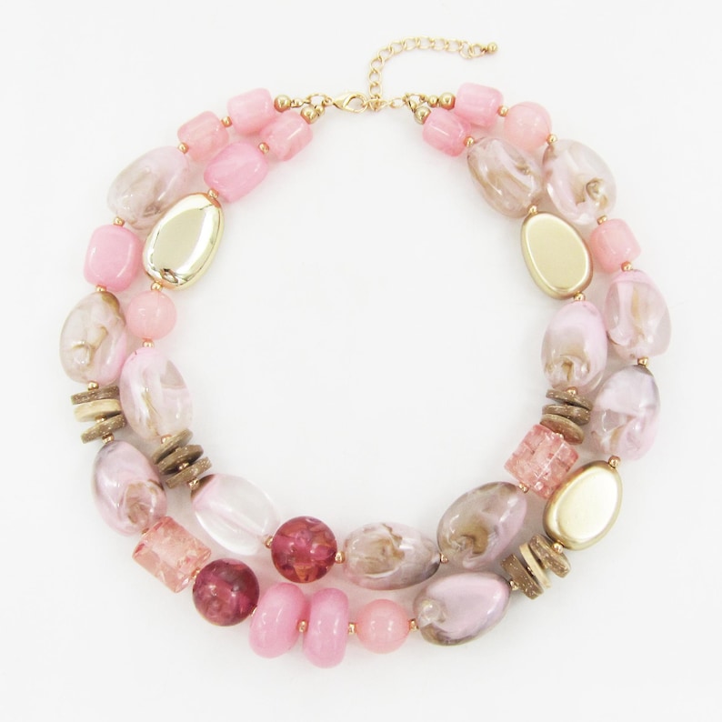 Pu&ograve; includere: Una collana a due fili con una variet&agrave; di perline rosa, trasparenti e dorate. La collana include perline ovali, rotonde e rettangolari, con una catena e una chiusura color oro. La collana &egrave; progettata per un look a strati.