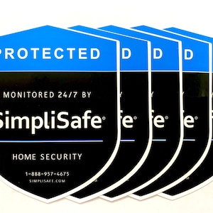 May include: Five blue and black shield-shaped stickers with the text "PROTECTED" and "MONITORED 24/7 BY SimpliSafe® HOME SECURITY 1-888-957-4675 SIMPLISAFE.COM"