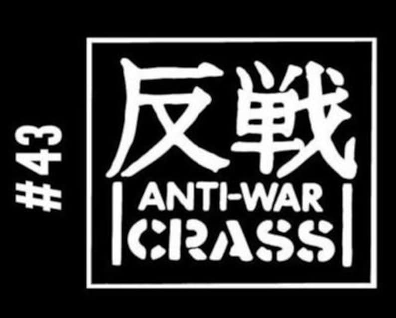 Puede incluir: Gr&aacute;fico en blanco y negro con el texto "反戦" en caracteres japoneses, "ANTI-WAR" y "CRASS" en letras blancas sobre fondo negro. El gr&aacute;fico est&aacute; en un marco cuadrado con el n&uacute;mero "#43" en letras blancas sobre fondo negro a la izquierda del marco.