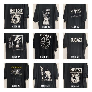 Op de afbeelding: Negen zwarte T-shirts met verschillende bandlogo's die op de voorkant zijn gedrukt. De logo's zijn "Infest", "Limp Wrist", "Flipper", "Bad Brains", "Crass", "Fugazi", "Die Kreuzen", "Discharge" en "Infest".