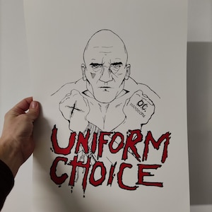 May include: Black and white line drawing of a man with a shaved head and a serious expression. He is wearing a shirt and has his fists clenched. The text "UNIFORM CHOICE" is written in red below the man. The text "OC HARDCORE" is written in black on his right fist.