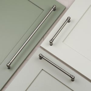 Pode incluir: Três puxadores de armário prateados com pontas arredondadas. Os puxadores são mostrados em portas de armário de diferentes cores.