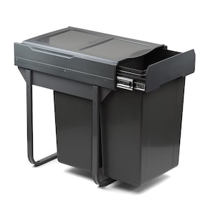 Puede incluir: Un cubo de basura gris extraíble con dos compartimentos. El cubo de basura tiene una tapa y un marco de metal.