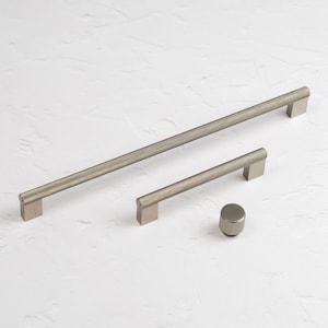 May include: Three silver cabinet pulls with a textured finish. The pulls are in different sizes. The smallest pull is a knob.