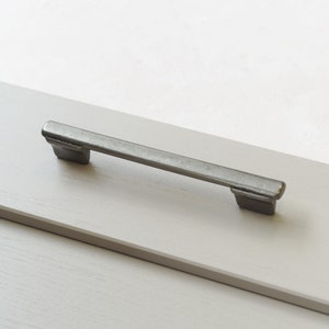 以下が含まれることがあります： 長方形でわずかに丸みを帯びたエッジを持つ銀色のキャビネットプル