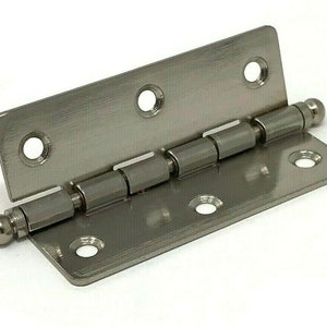 May include: A silver-toned metal hinge with rounded ball-shaped ends. The hinge has five visible barrel-shaped pins.