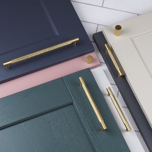 Puede incluir: Un juego de herrajes para armarios de color dorado con acabado texturizado. El juego incluye tiradores y pomos de varios tamaños.