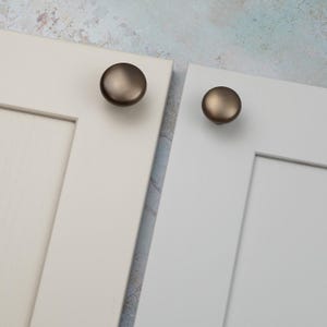 Peut inclure: Ensemble de trois tasses en c&eacute;ramique avec une finition mate et mouchet&eacute;e. Les tasses sont de couleur cr&egrave;me, gris clair et gris fonc&eacute;. Chaque tasse a un design simple et minimaliste.