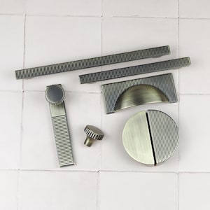Könnte beinhalten: Sortiment an antikem Messing-Schrankbeschlägen, darunter Griffe, Knöpfe und Schubladenzüge. Die Beschläge haben ein gerilltes Design und verschiedene Formen.