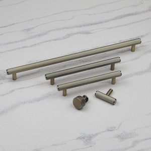 May include: A selection of bronze-coloured cabinet hardware, including bar pulls and a knob. The pulls feature a ridged texture and come in different lengths. The knob has a similar ridged design. All pieces have a matte finish.