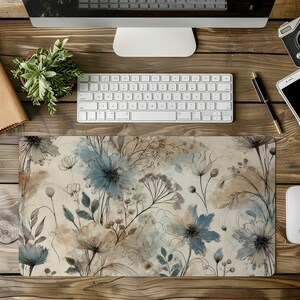 May include: A floral desk mat with a light beige background and a pattern of blue and brown flowers. The mat is designed to protect your desk surface from scratches and spills.