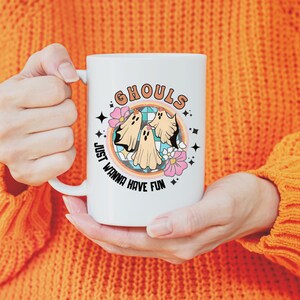 May include: White ceramic mug with a colorful graphic of three ghosts and the text "Ghouls Just Wanna Have Fun".