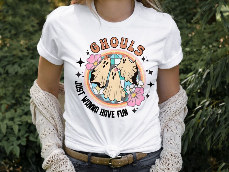 May include: White t-shirt with a graphic of three ghosts in a rainbow circle. The text "Ghouls Just Wanna Have Fun" is written around the circle.