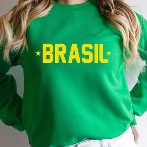 Puede incluir: Sudadera verde con texto amarillo que dice "*BRASIL*"