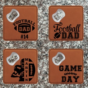 Puede incluir: Cuatro posavasos de cuero marrón con abridores de botellas. Los posavasos presentan diferentes diseños con temática de fútbol, incluyendo "Football Dad #14", "Football Dad", "Martin" con una silueta de jugador de fútbol y "Game Day".