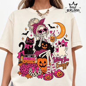 Peut inclure: Un t-shirt crème avec un motif représentant un squelette portant un bandeau léopard et des lunettes en forme de cœur, tenant une boisson à la citrouille. Le design inclut un chat noir, un fantôme, des citrouilles, des livres et le texte Witchy Boo Energy.
