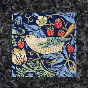 May include: Square fabric featuring a bird and strawberry pattern. The bird is beige and green, set against red strawberries, yellow flowers, and blue leaves on a navy background. The fabric has a vintage, botanical theme.