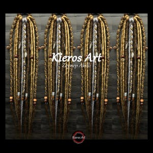 May include: A set of synthetic dreadlocks in shades of brown, blonde, and grey, featuring braided sections, metallic charms, and wooden beads. The text 'Kieros Art Zeynep Akıllı' is overlaid on the image, with a small logo at the bottom.