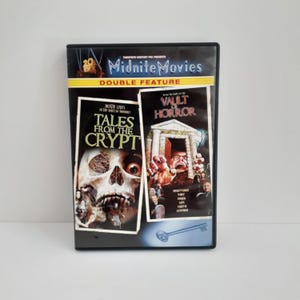 May include: A Midnite Movies double feature DVD case featuring Tales from the Crypt and Vault of Horror. The cover art displays a skull, a stone structure with a screaming figure, and a key graphic. Text includes Twentieth Century Fox Presents.