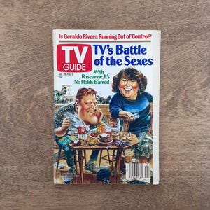 May include: A vintage TV Guide magazine from January 28 to February 3, featuring a caricature illustration of John Goodman and Roseanne Barr at a table. The cover text reads Is Geraldo Rivera Running Out of Control? and TV's Battle of the Sexes.