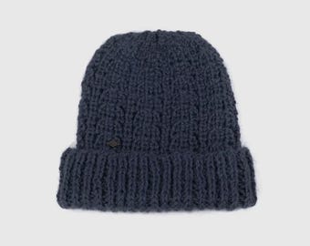 May include: A dark blue knitted beanie with a cable knit pattern.