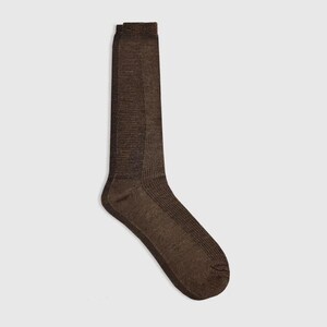 May include: A pair of brown socks. The socks are made of a textured material and have a ribbed design on the upper portion. The socks are knee-high and are displayed against a light background.