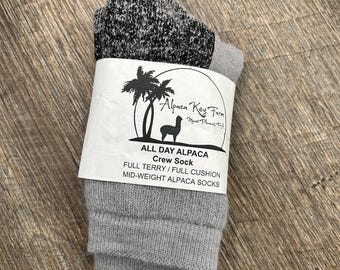 Puede incluir: Calcetines de tripulación de alpaca grises con una etiqueta blanca que dice "Alpaca Key Farm" y "All Day Alpaca Crew Sock" con el texto "Full Terry/Full Cushion Mid-Weight Alpaca Socks".