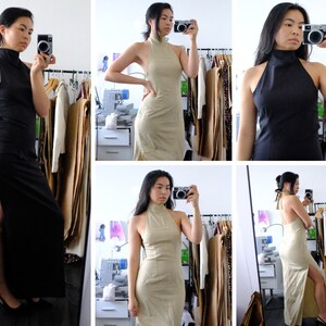 Puede incluir: Una mujer lleva un vestido negro de tirantes con cuello alto y una abertura en el muslo. El vestido est&aacute; hecho de una tela el&aacute;stica y tiene una silueta ajustada. La mujer est&aacute; de pie frente a un espejo y se est&aacute; tomando una selfie.