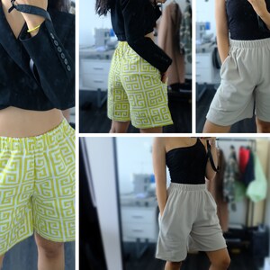 Op de afbeelding: Drie verschillende shorts. Het eerste paar is een gele en witte geometrische print. Het tweede paar is een lichtgrijs met een geometrische print. Het derde paar is een effen lichtgrijs.