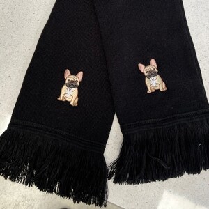 May include: Black knitted scarf with a fringe border and two embroidered French bulldog images.